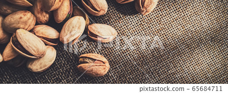 Pistachio nuts on rustic linen background Pistachio nuts on rustic linen background 65684711