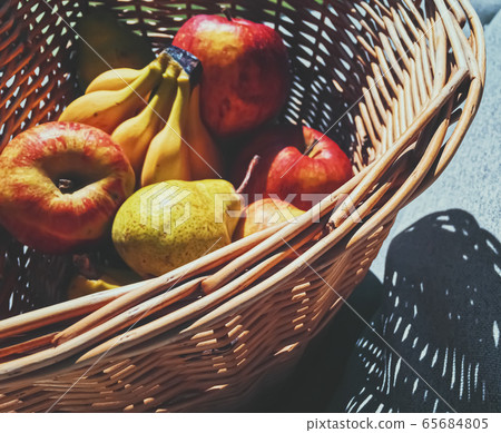 Organic apples, pears and bananas on rustic in a wicker basket 65684805