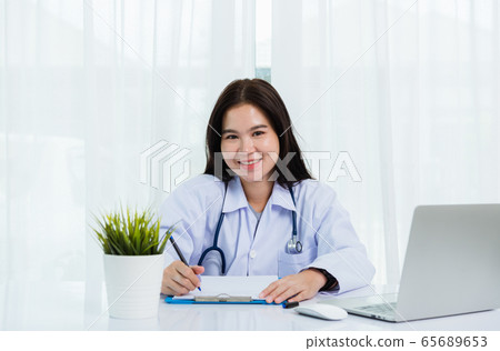 Doctor woman writing something on paperwork or 65689653