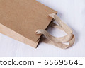 Packaging template mock up. Handle made of natural materials. Part of the package. Disposable small craft paper bag for takeaway on white table in the interior. Flatlay mock up. Place for text 65695641