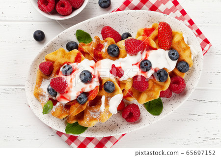 Delicious belgian waffles with summer berries Delicious belgian waffles with summer berries 65697152