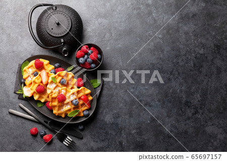 Delicious belgian waffles with summer berries Delicious belgian waffles with summer berries 65697157