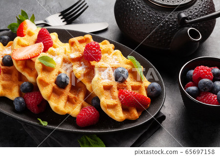 Delicious belgian waffles with summer berries Delicious belgian waffles with summer berries 65697158