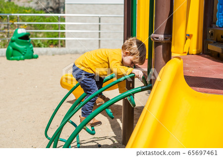 A boy climbs on playground A boy climbs on playground 65697461