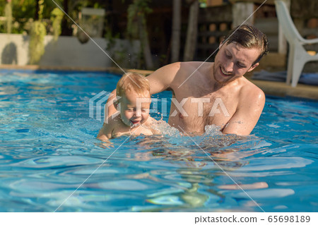 Dad teaches his son to swim 65698189