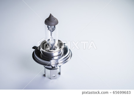 One new halogen light with an H4 cinder on a grey gradient background. New car parts for external car lighting systems 65699683