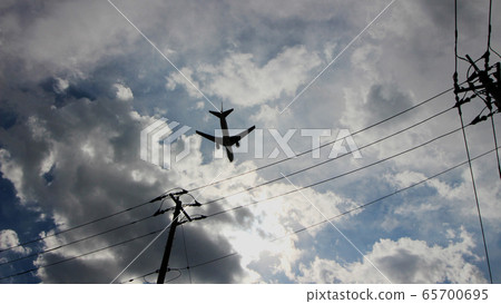 Jet airliner flying low above a residential area 65700695