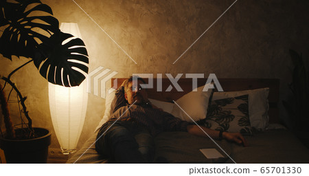 Man switching lighting on and off with home hub 65701330
