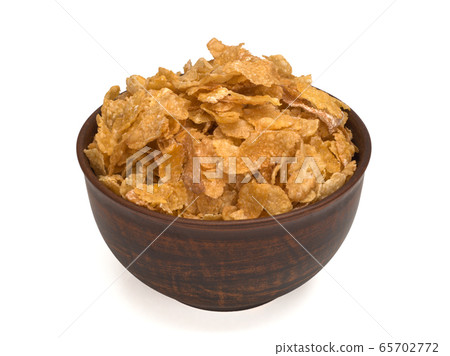 Corn flakes in bowl on white background Corn flakes in bowl on white background 65702772