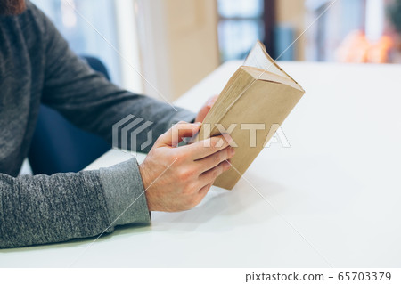 Young man reading open old paper book 65703379