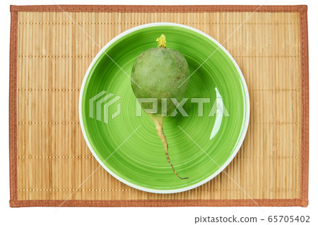 big green radish on a green plate on a cane 65705402