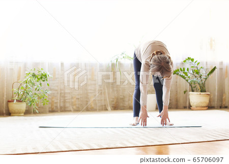 Mature woman stretching body on floor Mature woman stretching body on floor 65706097