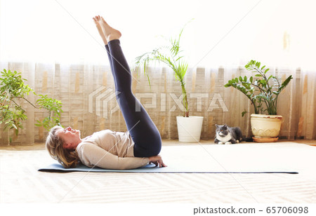 Mature woman stretching body on floor Mature woman stretching body on floor 65706098