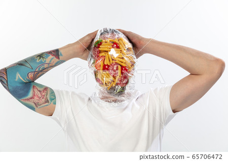 Male face covered with oilcloth, cellophane and unhealthy food, hard to breathe. People lost their faces, can't notice the environmental pollution made by themself. Male face covered with oilcloth, cellophane and unhealthy food, hard to breathe. People lost their faces, can't notice the environmental pollution made by themself. 65706472