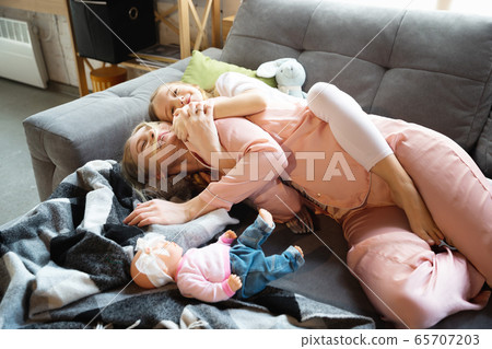 Mother and daughter, sisters have quite, beauty and fun day together at home. Comfort and togetherness. Hugging, cozy and happy. 65707203