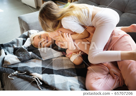 Mother and daughter, sisters have quite, beauty and fun day together at home. Comfort and togetherness. Hugging, cozy and happy. 65707206