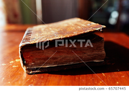 Old volumetric closed book on a wooden table Old volumetric closed book on a wooden table 65707445
