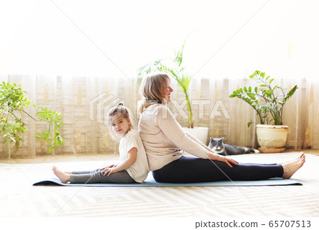 Grandmother and granddaughter meditating together 65707513