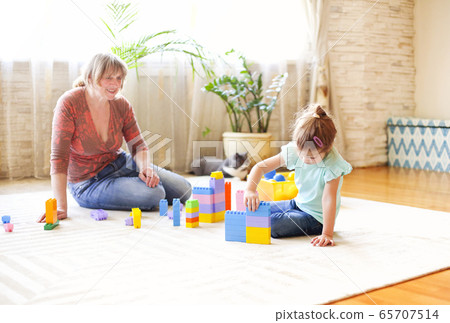 Happy grandmother playing with granddaughter on 65707514