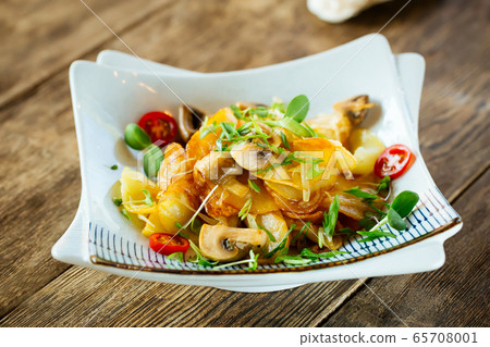 Closeup on fried potatoes with mushrooms greens 65708001