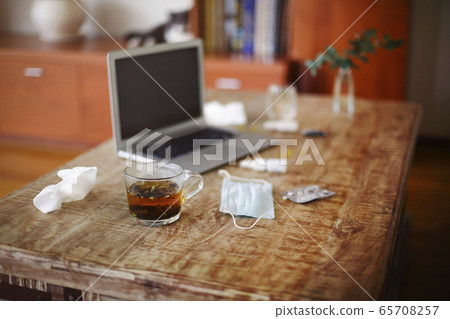 Medications on table near laptop 65708257