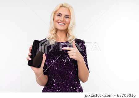girl in a dress advises the phone holding the screen forward with the layout for advertising on a girl in a dress advises the phone holding the screen forward with the layout for advertising on a 65709016