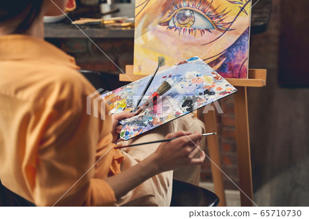 Female artist drawing picture with paints at home Female artist drawing picture with paints at home 65710730