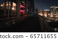 pedestrian railway bridge and the lights of a passing train at night 65711655