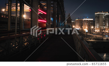 pedestrian railway bridge and the lights of a passing train at night pedestrian railway bridge and the lights of a passing train at night 65711655