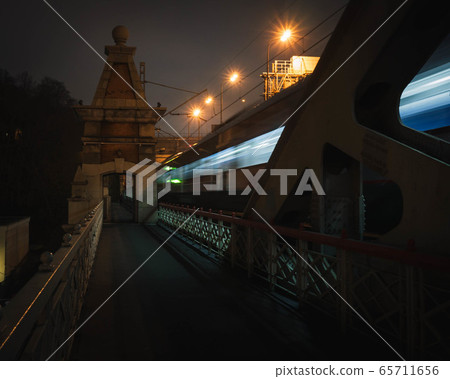 pedestrian railway bridge and lights of a passing train pedestrian railway bridge and lights of a passing train 65711656