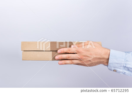 Pizza boxes in male hands. White background. Side Pizza boxes in male hands. White background. Side 65712295