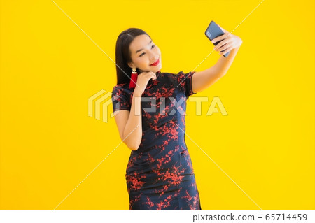 Portrait beautiful young asian woman wear chinese dress use smart mobile phone 65714459