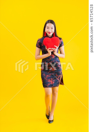 Portrait beautiful young asian woman wear chinese dress show heart shape pillow Portrait beautiful young asian woman wear chinese dress show heart shape pillow 65714528