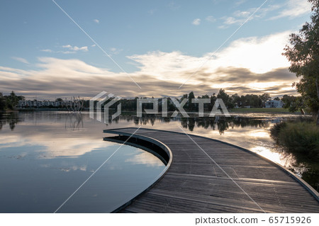 Fragment of stream in the middle of the lake and sky with clouds 65715926