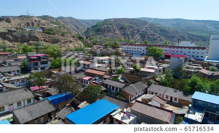 Aerial view of small poor town next the arid terraced farm firld mountain Aerial view of small poor town next the arid terraced farm firld mountain 65716534