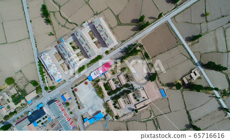 Aerial view of small poor village with school in the middle of dry farmland Aerial view of small poor village with school in the middle of dry farmland 65716616