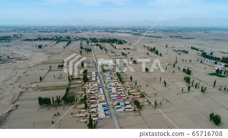 Aerial view of small poor village with school in the middle of dry farmland Aerial view of small poor village with school in the middle of dry farmland 65716708