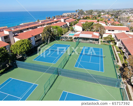 Aerial view of typical south california community condo with tennis court and pool 65717392