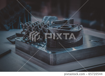 Man is holding object printed on metal 3d printer. Man is holding object printed on metal 3d printer. 65720544