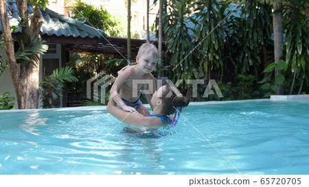 Young pretty cheerful Woman with her son Enjoying at a Pool Indoors. Slow Motion. Relax and Spa Concept 65720705