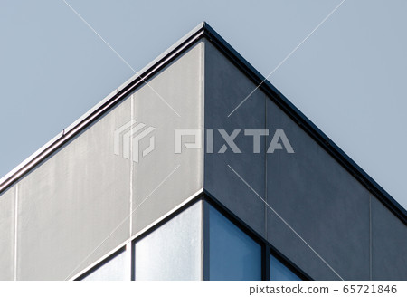 corner of a gray concrete building with windows 65721846