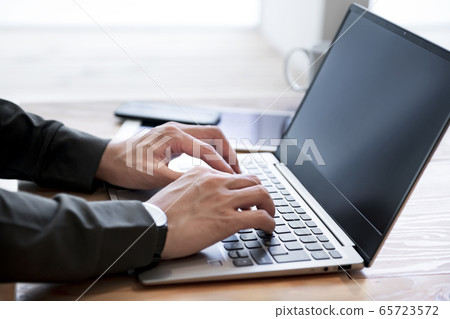 操作膝上型計算機的一個年輕人的手 操作膝上型計算機的一個年輕人的手 65723572