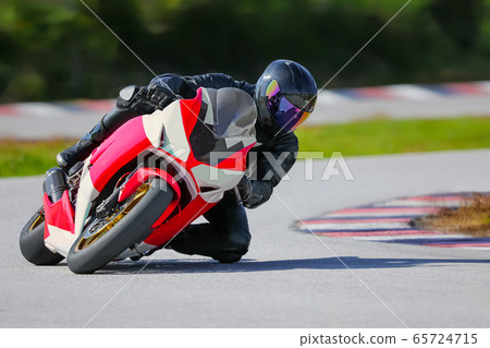 Motorcycle leaning into a fast corner on race Motorcycle leaning into a fast corner on race 65724715