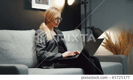 Businesswoman working laptop on couch 65725377