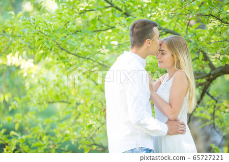 Young man kissing a beautiful girl on a forehead 65727221