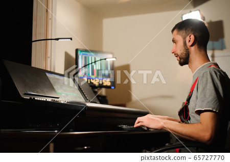 A lighting engineer works with lights technicians control on the concert show.  65727770