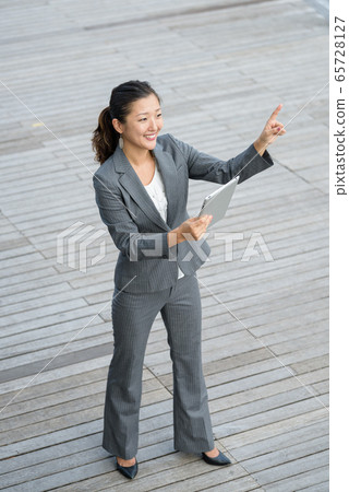 Businesswoman using iPad outdoors 65728127