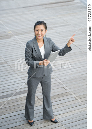 Businesswoman using iPad outdoors 65728129