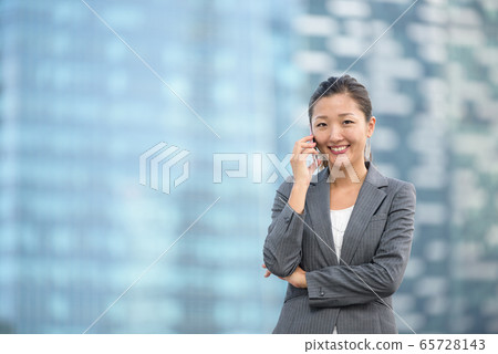 Successful businesswoman making voice call outdoors 65728143