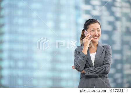 Successful businesswoman making voice call outdoors 65728144